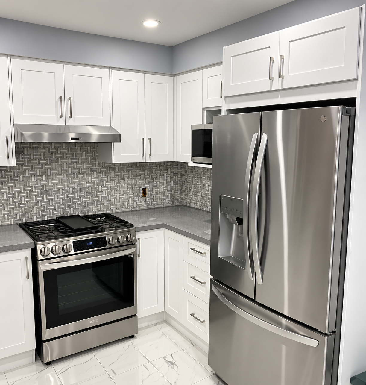 Enhanced view of compact white kitchen cabinetry around stainless steel appliances