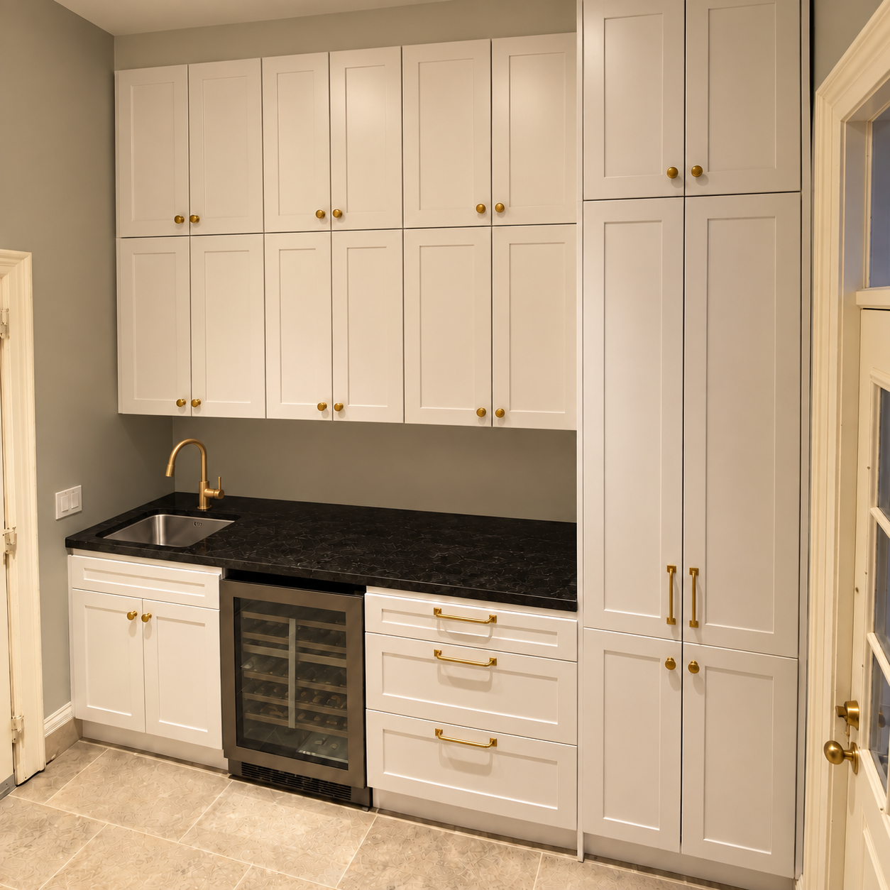 White entertainment bar cabinets with a black countertop, wine cooler, small sink and gold faucet